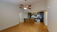 Located at 2720 Dawson Rd in Albany, Georgia, this single-floor unit offers a well-designed, open-concept layout that seamlessly connects the living area and kitchen. The main living space features warm hardwood-style flooring and vaulted ceilings accentuated by a ceiling fan, creating an airy and spacious feel throughout.

The kitchen is a standout feature, outfitted with rich, dark wood cabinetry that extends to the ceiling for ample storage, granite-style countertops, and a full suite of stainless steel appliances including a refrigerator, electric range, built-in microwave, and dishwasher. A raised kitchen island provides additional prep space and serves as a natural divider between the kitchen and living area. Pendant lighting above the island adds a refined touch.

The bedrooms are generously sized, each featuring plush carpeting, ceiling fans with light fixtures, and windows that allow for natural light. The bathrooms are clean and functional, featuring a tub-shower combination, wood-tone vanity cabinetry with granite-style countertops, and wood-look tile flooring. A dedicated utility room houses the water heater, providing practical storage and mechanical space. The overall ambiance is comfortable, modern, and move-in ready.