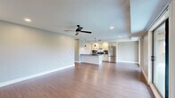 Located at 112 Walnut Blvd in Rochester, MI, this thoughtfully designed 2-bedroom, 2-bathroom residence offers a comfortable and modern living experience across a single floor. The open-concept layout seamlessly connects the living room, dining area, and kitchen, all unified by warm hardwood-style flooring and recessed lighting. The living room is bright and airy, featuring a ceiling fan and sliding glass doors that lead to a private balcony with outdoor views of surrounding greenery.

The kitchen is well-equipped with white shaker cabinetry, dark granite countertops, a subway tile backsplash, stainless steel appliances including a refrigerator and range, and a central island with pendant lighting — ideal for both cooking and entertaining.

A long, well-lit hallway connects the main living spaces to the bedrooms, which feature plush carpeting and ceiling fans. The generously sized primary bedroom includes a walk-in closet outfitted with built-in shelving and hanging rods. Both bathrooms are finished with cream cabinetry, dark granite countertops, framed mirrors, and glass-enclosed showers set atop light tile flooring.

Additional conveniences include a dedicated laundry area, utility room, and multiple closets throughout. The neutral color palette and consistent finishes create a cohesive, move-in-ready ambiance throughout the entire space.