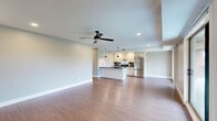 Located at 112 Walnut Blvd in Rochester, MI, this thoughtfully designed 2-bedroom, 2-bathroom residence offers a comfortable and modern living experience across a single floor. The open-concept layout seamlessly connects the living room, dining area, and kitchen, all unified by warm hardwood-style flooring and recessed lighting. The living room is bright and airy, featuring a ceiling fan and sliding glass doors that lead to a private balcony with outdoor views of surrounding greenery.

The kitchen is well-equipped with white shaker cabinetry, dark granite countertops, a subway tile backsplash, stainless steel appliances including a refrigerator and range, and a central island with pendant lighting — ideal for both cooking and entertaining.

A long, well-lit hallway connects the main living spaces to the bedrooms, which feature plush carpeting and ceiling fans. The generously sized primary bedroom includes a walk-in closet outfitted with built-in shelving and hanging rods. Both bathrooms are finished with cream cabinetry, dark granite countertops, framed mirrors, and glass-enclosed showers set atop light tile flooring.

Additional conveniences include a dedicated laundry area, utility room, and multiple closets throughout. The neutral color palette and consistent finishes create a cohesive, move-in-ready ambiance throughout the entire space.