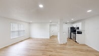 Located at 5300 Catalina Circle Dr in Hilliard, Ohio, this 1-bedroom, 1-bathroom residence offers a thoughtfully designed single-floor layout with a clean, modern aesthetic. The open-concept living and kitchen area is bright and inviting, featuring light-toned hardwood-style flooring, recessed lighting, and crisp white walls that amplify the sense of space. Natural light filters in through blinded windows, enhancing the airy atmosphere throughout.

The kitchen is well-equipped with white shaker-style cabinetry accented by matte black hardware, light stone countertops, a stainless steel sink, and a full suite of stainless steel appliances including a refrigerator, electric range, and microwave. A peninsula-style counter separates the kitchen from the living area, providing additional prep and dining space.

The bedroom offers plush carpeting, a ceiling fan with light fixture, and a window with blinds, creating a comfortable and restful retreat. The full bathroom includes a tub/shower combination with a curtain rod, toilet, and clean white finishes. A dedicated laundry closet houses a full-size washer and dryer. A hallway and closet complete the functional layout, making this a practical and move-in-ready home.