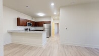 This single-story residence offers 2 bedrooms and 3 bathrooms thoughtfully arranged across a single level. Light-toned luxury vinyl plank flooring runs consistently throughout the home, lending a clean, cohesive aesthetic to every room.

The kitchen is a standout feature, showcasing rich dark-wood cabinetry with sleek hardware, granite-look countertops, a white tile backsplash, and a full suite of stainless steel appliances including a range, microwave, and refrigerator. A peninsula extends the counter space and provides a natural transition into the adjacent living area. The living room is bright and open, featuring a ceiling fan, a large window, and a glass door that invites natural light throughout the space.

The two bedrooms are comfortably sized — the primary bedroom offers a generous footprint — and both feature the same light flooring found elsewhere in the home. A dedicated closet provides additional storage. The three bathrooms are finished consistently with dark wood vanities topped with granite-look counters, brushed nickel fixtures, white subway-tiled tub-shower combinations, and light-toned flooring, creating a clean and functional environment.

The overall ambiance of the home is modern and neutral, with a bright, airy feel supported by recessed lighting and a light color palette throughout.
