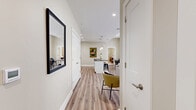 Located at 112 Market St in downtown Harrisburg, PA, this 2-bedroom, 2-bathroom residence offers a well-designed single-floor layout with a cohesive, contemporary aesthetic throughout. The open-concept living, dining, and kitchen area serves as the heart of the home, bathed in natural light from expansive floor-to-ceiling windows that frame urban views. Warm wood-look vinyl flooring flows seamlessly through the main living spaces, lending a clean, modern feel.

The kitchen is well-appointed with crisp white shaker cabinetry, dark granite countertops, a hexagonal tile backsplash, and a full suite of stainless steel appliances. A kitchen island with pendant lighting provides additional counter space and casual seating, while a dedicated dining area accommodates a full table setting.

Both bedrooms are finished with plush carpeting and neutral tones, offering a calm retreat. The primary bedroom is generously proportioned and includes a large double-door closet. Each bathroom features white cabinetry with ample storage, white quartz countertops, and wood-look flooring for a consistent, polished look.

Additional highlights include a dedicated laundry area, four closets for plentiful storage, a welcoming entry hallway, and a neutral warm-beige color palette throughout that creates a bright, inviting atmosphere.