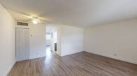 Located at 400 NW 34th St in Pompano Beach, Florida, this single-floor residence offers a clean, modern interior with a thoughtfully updated design. Wood-look plank flooring runs consistently throughout the living areas and bedrooms, providing a warm and cohesive aesthetic. The spacious living room features a textured ceiling, a ceiling fan, and natural light from a large window with vertical blinds, creating an open and airy atmosphere.

The kitchen stands out with its contemporary two-tone cabinetry — dark wood lower cabinets paired with high-gloss white upper cabinets — complemented by light quartz countertops, recessed lighting, and white appliances including a range and refrigerator. The layout maximizes counter and storage space efficiently.

The bathroom is finished with white tile flooring, a quartz-topped vanity with dark wood cabinetry, and a tub-shower combination enclosed by sliding glass doors with tasteful tile accents. Additional rooms include well-proportioned bedrooms with bright white walls, wood-look flooring, and closet access. The overall interior presents a neutral, move-in-ready palette with consistent modern finishes throughout, making it a functional and attractive single-level residence in Pompano Beach.