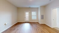 This 730 square foot apartment in Normal, Illinois, offers a thoughtfully designed living space. The single-story layout maximizes efficiency, featuring one bedroom and one bathroom. The heart of the home is an open-concept living area that seamlessly integrates the kitchen and living room.

The modern kitchen is a standout feature, boasting a combination of white upper cabinets and darker lower cabinets for visual interest. Stainless steel appliances, including a refrigerator and built-in microwave, add a contemporary touch. A central island with a sink provides additional counter space and defines the kitchen area.

The living room is spacious and bright, with hardwood flooring that extends throughout most of the apartment. Large windows allow ample natural light, creating an airy atmosphere. The bedroom, measuring 200 square feet, offers plush carpeting for comfort and a closet for storage.

The bathroom features a single vanity with ample counter space, a modern fixture, and a combination tub/shower. The apartment also includes a dedicated closet space with wire shelving for additional storage.

Throughout the space, neutral wall colors and clean lines contribute to a modern, minimalist aesthetic. Recessed lighting and pendant fixtures in the kitchen provide both ambient and task lighting. This well-designed apartment efficiently utilizes its 730 square feet to create a comfortable and stylish living environment.