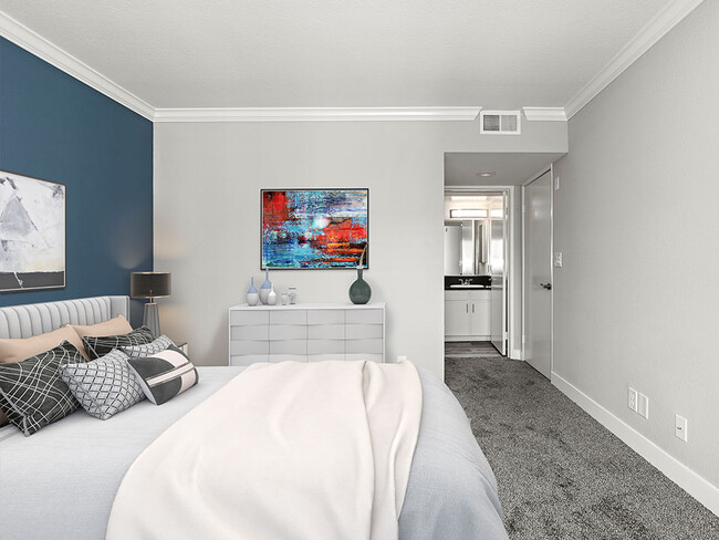 Carpeted bedroom with blue accent wall. - Magnolia Terrace