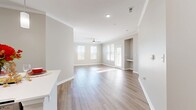This contemporary 1250 square foot apartment offers a harmonious blend of functionality and style. The open-concept layout seamlessly integrates the kitchen and living areas, creating an inviting space for both relaxation and entertainment. The kitchen boasts sleek stainless steel appliances, ample wooden cabinetry, and a practical island with pendant lighting.

Two well-appointed bedrooms provide comfortable retreats, with the primary bedroom measuring a spacious 150 square feet. Both bathrooms feature modern fixtures, including vanities with wooden cabinets and large mirrors. The unit includes an in-unit laundry room with full-sized washer and dryer, enhancing convenience for residents.

Throughout the apartment, a neutral color palette of soft grays and whites creates a calming atmosphere, while large windows allow natural light to flood the space. The flooring alternates between warm hardwood in the main living areas and plush carpeting in the bedrooms, adding texture and comfort.

Ceiling fans in the bedrooms and living area provide additional climate control. The apartment's thoughtful design maximizes space efficiency, with features like built-in closets for ample storage. Located in Charleston, SC, this unit offers a perfect balance of modern amenities and classic charm.