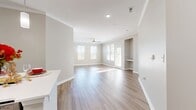 This contemporary 1250 square foot apartment offers a harmonious blend of functionality and style. The open-concept layout seamlessly integrates the kitchen and living areas, creating an inviting space for both relaxation and entertainment. The kitchen boasts sleek stainless steel appliances, ample wooden cabinetry, and a practical island with pendant lighting.

Two well-appointed bedrooms provide comfortable retreats, with the primary bedroom measuring a spacious 150 square feet. Both bathrooms feature modern fixtures, including vanities with wooden cabinets and large mirrors. The unit includes an in-unit laundry room with full-sized washer and dryer, enhancing convenience for residents.

Throughout the apartment, a neutral color palette of soft grays and whites creates a calming atmosphere, while large windows allow natural light to flood the space. The flooring alternates between warm hardwood in the main living areas and plush carpeting in the bedrooms, adding texture and comfort.

Ceiling fans in the bedrooms and living area provide additional climate control. The apartment's thoughtful design maximizes space efficiency, with features like built-in closets for ample storage. Located in Charleston, SC, this unit offers a perfect balance of modern amenities and classic charm.