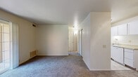 Located at 2610 Deloak Dr in Saint Louis, MO 63129, this one-bedroom, one-bathroom unit offers a practical and well-organized single-floor layout. The living room is the centerpiece of the home, featuring plush carpeted flooring, a ceiling fan, and a large sliding glass door that opens onto a private balcony, filling the space with natural light and providing outdoor access. A textured block-style accent wall adds a distinctive architectural detail near the entry, which is equipped with a six-panel door and gold-tone hardware.

The bedroom is a comfortable, well-proportioned room with carpeted flooring, a window that brings in natural light, and access to a dedicated closet with louvered bifold doors, offering ample storage. The bathroom is clean and functional, featuring tile flooring, a tub/shower combo with white subway-style tile surround, and a vanity with a sink. The kitchen area, visible in the dollhouse view, includes white cabinetry. Throughout the unit, the neutral color palette of whites and warm beiges creates a bright, cohesive atmosphere that is easy to personalize.
