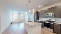Located at 110 Cool Springs Dr in Elizabethtown, KY, this 2-bedroom, 2-bathroom unit is thoughtfully designed across a single floor. The open-concept kitchen and living area serves as the heart of the home, anchored by a large center island with a granite countertop and undermount sink, illuminated by modern pendant lighting. The kitchen is outfitted with rich dark-toned cabinetry, a stainless steel appliance suite including a refrigerator, range, and microwave, and a clean tile backsplash. Hardwood-style flooring flows throughout the main living areas, complemented by crown molding and recessed lighting. The living room benefits from abundant natural light through multiple windows and features a ceiling fan. Both bedrooms are carpeted and bright, each equipped with ceiling fans and generous windows. The primary bedroom includes access to a walk-in closet with wire shelving. A second walk-in style closet is also present elsewhere in the unit, totaling four closets throughout. The bathrooms feature tub-shower combinations and wood-look tile flooring. Additional conveniences include an in-unit laundry area. A private exterior door off the living space provides outdoor access, rounding out this well-appointed and functional home.