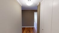 Located at 1631 Laurel Ave in Knoxville, Tennessee, this single-floor unit offers a well-organized layout with consistent design elements throughout. Rich, warm-toned hardwood floors run throughout the entire space, lending a sense of continuity and character from room to room. Crown molding accents the ceilings, adding a clean, classic finish to each area.

The living area is generously sized, featuring a ceiling fan with light fixture and neutral taupe-toned walls that create a warm, inviting atmosphere. Natural light filters in through windows fitted with horizontal blinds, brightening the space comfortably.

The bedrooms are well-proportioned, each with the same warm hardwood flooring and neutral wall palette. One bedroom includes a built-in closet with shelving and a hanging rod, offering practical storage. Wall-mounted HVAC units are present in the bedrooms, providing individual climate control.

The kitchen features white cabinetry, dark countertops, a double basin sink, and white appliances including an electric range and a full-size refrigerator. A globe ceiling light illuminates the space efficiently.

The bathroom is clean and straightforward, equipped with a full tub-shower combination featuring white tile surround. Hallways are accented with globe light fixtures and crown molding, connecting the rooms cohesively throughout the unit.