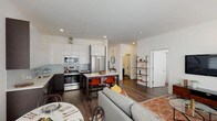 Located at 270 Waverly Ave in Mamaroneck, NY, this 2-bedroom, 2-bathroom residence offers a sleek, modern design across a single floor. The open-concept living, dining, and kitchen area forms the heart of the home, with rich hardwood-style flooring, recessed lighting, and large windows that flood the space with natural light. The kitchen is outfitted with stainless steel appliances, two-tone cabinetry featuring white upper cabinets and dark lower cabinets, light quartz countertops, and a soft blue glass tile backsplash. A kitchen island with bar seating provides an ideal spot for casual dining. The living area is generously proportioned, featuring large roller-shade windows that offer abundant light and a comfortable, airy atmosphere. The primary bedroom is a serene retreat with wide windows, hardwood-style floors, and clean white walls. The second bedroom is bright and versatile, easily serving as a guest room or home office. Both bathrooms are finished with large-format gray floor tiles, soaking tub-shower combinations accented by distinctive aqua glass tile surrounds, and modern vanities with illuminated medicine cabinets. Throughout, the residence maintains a cohesive, contemporary aesthetic with neutral tones and quality finishes.