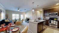 Located at 15650 Walden Rd in Montgomery, Texas, this single-floor residence offers a thoughtfully designed open-concept layout that seamlessly connects the kitchen, dining, and living areas. The kitchen is a standout feature, equipped with rich dark-wood cabinetry, granite countertops, stainless steel appliances including a refrigerator, range, microwave, and dishwasher, along with a central island with a double sink and pendant lighting overhead. Crown molding and wood-style flooring add polish to the kitchen and main living areas.

The living room is bright and welcoming, with large windows and a glass door that open to a private balcony, filling the space with natural light. A ceiling fan enhances comfort, and plush carpeting provides a warm, relaxed atmosphere.

The bedroom is generously sized with soft carpet flooring, multiple windows allowing ample natural light, and a ceiling fan. The space offers a calm and comfortable retreat.

Two bathrooms serve the residence. The primary bathroom features a walk-in glass-enclosed shower, a granite-topped vanity with dark wood cabinetry, and wood-style flooring. The secondary bathroom includes a shower-tub combination, a matching granite vanity, and consistent finishes that tie the space together cohesively throughout.