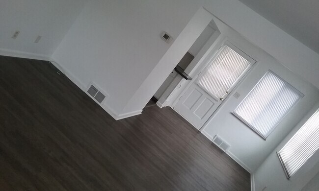 Living room and dining room view facing back door new flooring - 907 Davis Ave.
