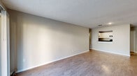 Located at 6115 N Davis Hwy in Pensacola, Florida, this one-bedroom, one-bathroom unit offers a well-organized single-floor layout designed for comfortable everyday living. The open living room is finished with durable wood-style flooring and neutral-toned walls, creating a bright and inviting atmosphere. A sliding glass door fills the space with natural light and provides direct access to an outdoor green area. The kitchen connects to the living area via a pass-through counter and features white cabinetry, dark granite-style countertops, and black stainless appliances including a refrigerator, range, and dishwasher, all set over matching wood-style flooring. A textured ceiling carries throughout the main living spaces. The bedroom is generously sized, finished with plush carpet, a ceiling fan with light fixture, and a window that allows in natural light. A walk-in closet with built-in shelving and hanging rods provides ample storage. The bathroom is outfitted with a tub-shower combination, a white vanity with dark countertop, and wood-style tile flooring, maintaining a cohesive design aesthetic throughout the unit. Clean, functional, and well-appointed, this Pensacola residence offers a comfortable and efficient living environment.