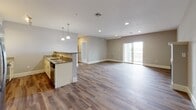 Located at 99 Water St in Warren, Rhode Island, this single-floor residence offers a well-designed, open-concept layout finished with contemporary details throughout. The expansive living and dining area flows seamlessly into the kitchen, where white raised-panel cabinetry pairs with granite countertops, stainless steel GE appliances—including a French door refrigerator, electric range, and built-in microwave—and warm hardwood-style flooring. Pendant lighting above the kitchen peninsula adds a refined touch, while recessed lighting illuminates the open living space. Sliding glass doors lead to a private balcony, bringing in generous natural light and outdoor views.

The bedrooms are finished with neutral-toned carpet and feature windows overlooking the surrounding landscape, creating a calm, restful atmosphere. Two full bathrooms mirror the home's consistent aesthetic, each appointed with granite-topped vanities, cream cabinetry, and hardwood-style flooring; one features a soaking tub and shower combination, while the other offers a standalone walk-in shower. A dedicated in-unit laundry area houses a full-size front-loading GE washer and dryer, adding everyday convenience. Neutral gray walls and white trim unify the space with a clean, modern sensibility throughout.