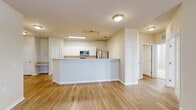 Located at Villa Capri Circle in Odessa, Florida, this 2-bedroom, 3-bathroom residence offers a well-designed single-floor layout with a bright, open feel throughout. The heart of the home is an open-concept kitchen and living area, where warm wood-style flooring flows seamlessly underfoot. The kitchen features white cabinetry, light countertops, stainless steel appliances including a refrigerator, range, microwave, and dishwasher, and a peninsula with a double sink that overlooks the living space. The spacious living room is bathed in natural light from multiple windows and a glass-panel door, and is accented by a ceiling fan overhead. French-style doors add an elegant touch to the living area's entry points. Both bedrooms are carpeted for comfort and include ceiling fans and windows with blinds. The primary bedroom features direct access to an en-suite bathroom and generous closet space. The bathrooms are clean and functional, with white vanities, framed mirrors, and tub-shower combinations. A dedicated laundry area and an abundance of closets — eight in total — provide exceptional storage. The overall palette of neutral beige tones and white trim creates a cohesive, move-in-ready aesthetic throughout the home.