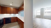 Located at 100 Temple St in the heart of New Haven, CT, this single-floor residence offers a clean, modern aesthetic throughout. Light-toned wood-look flooring flows seamlessly across the living areas, complementing the soft gray walls and crisp white trim that define the interior palette. The open living area is bright and generously proportioned, benefiting from large windows that invite ample natural light. A pass-through window connects the living space to the kitchen, creating an open, communicative layout. The kitchen is well-appointed with rich warm-toned cabinetry, white countertops, and a full suite of black appliances including an electric range, over-the-range microwave, refrigerator, and dishwasher, alongside a tiled floor that grounds the space. The unit includes multiple bedrooms, each featuring wood-look flooring, neutral walls, and windows providing natural light. Two full bathrooms serve the residence: one features a combination tub and shower with subway tile surround, a glass enclosure, warm wood vanity, and expansive wood-look flooring, while the second offers a standard tub-shower combo and matching vanity. The overall ambiance is clean, contemporary, and move-in ready, well-suited to urban living in downtown New Haven.