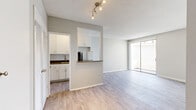 Located on Sepulveda Blvd in the Sherman Oaks neighborhood of Los Angeles, this single-floor unit offers a thoughtfully designed layout that maximizes every square foot. Light gray laminate wood flooring runs throughout, complementing the soft neutral wall tones and textured popcorn ceilings.

The open living area benefits from a large sliding glass door that floods the space with natural light and provides access to an outdoor area. A track lighting fixture overhead adds both functionality and a subtle modern touch.

The kitchen is partially open to the living space via a peninsula with a dark wood countertop, creating a convenient pass-through feel. Inside, the kitchen features white shaker cabinetry, white subway tile backsplash, dark countertops, stainless steel appliances including a range and refrigerator, and a single-basin sink. White louvered closet doors near the entry provide additional storage options.

The bathroom is clean and bright, finished with light wood-look flooring, white cabinetry with a stone-look countertop, and a full shower-tub combination with chrome fixtures. The overall design of the unit is consistent and cohesive, with a neutral palette that offers a versatile canvas for personalization.
