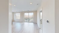 This well-appointed 2-bedroom, 2-bathroom residence at Kirkwood in Auburn Hills, Michigan offers a thoughtfully designed open-concept layout filled with natural light. The living and dining area features light-toned hardwood-style flooring, recessed lighting, and large sliding glass doors that open to a private balcony overlooking the surrounding landscape — an ideal space for relaxing or entertaining.

The kitchen is a standout feature, showcasing a modern island with a white quartz countertop, warm wood cabinetry, stainless steel appliances including a French door refrigerator, and stylish pendant lighting that adds a contemporary flair.

Both bedrooms are comfortably sized and carpeted, each benefiting from generous windows that invite abundant natural light and offer pleasant outdoor views. The rooms are finished with clean, neutral tones that create a calm and versatile atmosphere.

The two bathrooms are finished to a high standard, featuring floating wood-toned vanities with white countertops, modern black-framed mirrors, and light wood-style tile flooring. The primary bathroom includes a walk-in glass-enclosed shower, while the second bathroom offers a tub/shower combination.

A hallway and dedicated closet round out the thoughtfully organized floor plan, providing practical storage solutions. The cohesive neutral palette and modern finishes throughout create a bright, welcoming living environment.
