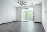 Located at 5124 Central Park Pl in Fitchburg, WI, this well-appointed one-bedroom, one-bathroom unit offers a thoughtfully designed single-floor layout that maximizes both comfort and functionality. The open-concept kitchen and living area serves as the heart of the home, featuring rich hardwood-style flooring, crisp white shaker cabinetry, a classic subway tile backsplash, and granite countertops throughout. A central kitchen island with pendant lighting provides additional workspace and a natural gathering point. Stainless steel appliances complete the kitchen's polished, modern aesthetic. The living area is bright and airy, with a ceiling fan overhead and a sliding glass door fitted with vertical blinds that opens to a private patio, offering pleasant outdoor views and generous natural light. The spacious primary bedroom is carpeted for comfort, equipped with its own ceiling fan, large windows, and access to two closets. The full bathroom continues the granite countertop theme with a well-sized vanity, undermount sink, and tiled flooring, maintaining a clean and cohesive design throughout. Neutral tones and modern finishes give the entire space a fresh, move-in-ready feel.