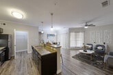 Located at 13922 Woodson Park Drive in Houston, TX, this thoughtfully designed one-bedroom, one-bathroom residence offers a comfortable and functional single-floor layout. The open-concept living area seamlessly connects the kitchen, dining, and living spaces, all finished with warm wood-style flooring and crown molding throughout.

The kitchen is a standout feature, boasting dark espresso cabinetry, granite countertops, a large peninsula with bar seating, pendant lighting, and a full suite of stainless steel appliances including a range, microwave, and refrigerator. A walk-in pantry provides generous storage. The dining area sits adjacent to the kitchen and benefits from natural light through vertical blinds.

The living room is bright and welcoming, with large windows, a ceiling fan, and neutral tones that create a relaxed atmosphere. The spacious bedroom features plush carpeting, crown molding, a ceiling fan, and windows with blinds for privacy. The bathroom includes a dark-cabinet vanity with granite countertops and a large mirror. A dedicated laundry area with wire shelving and an in-unit washer adds everyday convenience. A hallway closet rounds out the practical storage options in this well-designed home.