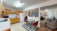 Located at 74 Sturgis Rd in Monticello, NY, this single-floor residence offers a practical and comfortable layout across six distinct areas. The kitchen is a standout feature, boasting an abundance of warm oak cabinetry that extends from floor to ceiling, providing ample storage and counter space. A white electric range, refrigerator, and double sink make this a fully functional cooking space, while light tile flooring adds a clean, bright aesthetic. The kitchen opens into a dining area with room for a cozy table and chairs, creating an inviting eat-in atmosphere. The living room is carpeted and well-proportioned, featuring a ceiling fan and a window with natural light, lending a relaxed and welcoming ambiance. The bedroom is comfortably sized, complete with carpet flooring, a ceiling fan, a sliding double-door closet, and a window that allows in natural light. The unit features an impressive six closets throughout, offering exceptional storage throughout the space. The bathroom is clean and functional, fitted with tile flooring, a vanity, grab bars, and tasteful wall décor. A connecting hallway ties the rooms together in a logical and accessible flow. Overall, this residence delivers comfort, practicality, and generous storage in a compact, well-organized footprint.