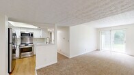 Located at 2907 North High Street in Columbus, OH, this single-floor unit offers 2 bedrooms and 2 bathrooms within a comfortable, efficiently designed layout. The kitchen stands out with crisp white shaker cabinetry, marble-look quartz countertops, stainless steel appliances including a range, built-in microwave, and dishwasher, complemented by warm hardwood-style flooring. The open cabinetry and clean lines create a bright, modern cooking space. Both bedrooms feature neutral carpet flooring, textured ceilings, and windows that allow natural light to filter in. The primary bedroom offers a generous footprint with ample wall space, while the second bedroom includes a sliding double-door closet for added storage. The bathrooms are finished with white shaker vanities topped with marble-look countertops and wood-style vinyl flooring. One bathroom features a tub and shower combination with classic white subway tile surround and brushed gold hardware accents, adding a refined touch. Throughout the unit, the neutral color palette of whites and warm beiges creates a cohesive and inviting atmosphere, making this a well-appointed space in a convenient Columbus location.