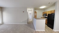 Located at 501 Tiger Way in Knoxville, Tennessee, this 2-bedroom, 2-bathroom residence offers a practical and comfortable single-floor layout. The open living area features neutral-toned carpet and connects seamlessly to the kitchen, which is equipped with warm honey-toned cabinetry, granite-look countertops, black appliances, and light wood-style flooring. A peninsula counter defines the boundary between the kitchen and living space, while the adjacent dining area features light wood-style flooring and an elegant pendant chandelier overhead. Both bedrooms are carpeted and finished with neutral tones, providing a calm and restful atmosphere. The spacious primary bedroom includes a ceiling fan and two closets, one of which is a generously sized walk-in closet fitted with wire shelving. The second bedroom also offers a closet with easy hallway access. Each bathroom is well-appointed — one features a granite-topped vanity with warm wood cabinetry and light wood-style flooring, while the other includes a full tub-shower combo with white tile surround. Throughout the residence, clean white trim, panel-style doors, and a consistent neutral color palette create a cohesive and inviting living environment.