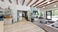 Located at 650 W Rand Rd in Arlington Heights, IL, this single-floor amenity space offers a thoughtfully designed environment spanning a generous footprint. The centerpiece is an expansive open lounge area distinguished by striking exposed wood ceiling beams, pendant lighting, and light hardwood flooring. A floor-to-ceiling tiled fireplace anchors the living area, complemented by large glass doors that invite natural light and offer views of the outdoor pool area, creating a seamless indoor-outdoor connection.

The fitness facilities are divided into two dedicated spaces: a fully equipped cardio and strength gym featuring modern treadmills, a stair climber, wall-mounted TVs, and sleek acoustic wall paneling, alongside a spacious yoga and movement studio with large windows overlooking the exterior grounds and open carpeted floors ideal for group classes or individual workouts.

Three private offices provide functional workspaces, each outfitted with contemporary light wood desks, modern lighting, and carpet flooring. The main leasing office reception area features a moss wall art installation and glass-partitioned conference rooms for private meetings. A cozy breakout nook with a round table offers additional collaborative space. A media room and closet round out the well-appointed layout, making this a versatile and polished community amenity hub.