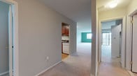Located at 5 Stonewain Court in Towson, Maryland, this single-floor residence offers a practical and comfortable layout with clearly defined living spaces. The interior is finished with neutral gray walls and plush wall-to-wall carpeting throughout the main living and bedroom areas, creating a warm and cohesive feel.

The kitchen is a standout feature, outfitted with rich medium-toned wood cabinetry, dark granite-style countertops, and black appliances including a gas range, refrigerator, and dishwasher. Durable hardwood-style flooring anchors the kitchen, providing a clean contrast to the carpeted areas beyond.

The main living area is generously proportioned, with a distinctive teal accent wall and a window that draws in natural light. A sliding glass door provides access to an outdoor area, further enhancing the sense of openness. Adjacent hallways connect seamlessly to the kitchen and bedroom spaces, facilitating an efficient flow throughout the unit.

The bedrooms are well-sized and carpeted, each featuring neutral walls and windows that allow natural light to filter in. Closet access is present in the bedroom areas, adding practical storage. An additional open room with carpeting offers flexible use as a den, office, or extra living space. Overall, the residence presents a clean, functional environment well-suited for comfortable everyday living.
