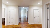 Located at 690 Park Rd in Inman, SC, this spacious single-floor residence blends industrial character with modern updates throughout. The interior is defined by striking white-painted exposed brick walls, rich reclaimed hardwood flooring, and high ceilings accented by wood planking and ceiling fans, creating an airy, loft-inspired ambiance.

The open-concept kitchen and living area serves as the heart of the home, featuring a granite peninsula with a double sink, dark espresso cabinetry, stainless steel refrigerator, gas range, and built-in microwave — all set against an exposed brick backdrop. The combined space flows naturally into the living area, which benefits from abundant natural light through large industrial-style windows.

The residence offers five bedrooms, varying in finish — some showcasing the warm hardwood floors, others carpeted for comfort, with select rooms retaining original brick accent walls and large windows. Each bedroom includes closet space with wire shelving systems for organized storage.

The single bathroom is cleanly appointed with wood-toned vanity cabinetry, granite countertop, hardwood flooring, and a full tub-shower combination. Two hallways connect the rooms efficiently across the single floor, ensuring a practical and functional layout throughout this distinctive Inman property.