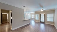 This well-appointed 1-bedroom, 1-bathroom unit in Spring, TX is designed with a modern, open-concept layout that maximizes comfort and functionality across a single floor. The living and dining area features rich hardwood-style flooring, crown molding, and a ceiling fan, while multiple windows with blinds allow natural light to fill the space. A private entry door adds a sense of seclusion and ease of access.

The kitchen is a standout feature, outfitted with dark espresso cabinetry, granite countertops, a tile backsplash, and a full suite of stainless steel appliances including a refrigerator, range, and dishwasher. A breakfast bar with pendant lighting serves as both a functional workspace and a natural connection to the living area, making it ideal for everyday dining or entertaining.

The bedroom is a calm retreat finished with plush carpeting, crown molding, a ceiling fan, and a well-proportioned window that brings in ample natural light. The bathroom is accessed via a dedicated hallway that also provides access to closet storage and a glass-enclosed shower, all finished with light hardwood-style flooring for a cohesive look throughout the unit.