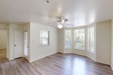 Located at 4545 S Panther Creek Drive in The Woodlands, TX, this one-bedroom, one-bathroom residence offers a thoughtfully designed single-floor layout. The open-concept living room is a standout space, featuring light hardwood-style flooring, a ceiling fan, and a striking curved bay window arrangement that floods the room with natural light and frames views of surrounding greenery. A secondary window further enhances the brightness and airy feel of this gathering space.

The kitchen is efficiently laid out with light wood cabinetry, granite-style countertops, a stainless steel refrigerator, and a range with overhead ventilation. A pass-through counter connects the kitchen to the living area, creating a cohesive, open flow ideal for everyday living and entertaining.

The bedroom is a comfortable retreat, finished with plush carpeting and corner windows that invite natural light while offering outdoor views. A dedicated closet provides ample storage.

The bathroom is clean and functional, featuring a full tub-shower combination with white tile surround, a granite-style vanity countertop, and neutral finishes throughout. The consistent use of light, warm tones across all rooms creates a cohesive and inviting ambiance throughout this well-appointed residence in The Woodlands.
