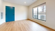 This 510 square foot apartment offers a contemporary living space with a thoughtful layout. The single-floor design comprises one bedroom, one bathroom, a combined kitchen and living area, and a hallway. The open-concept kitchen and living room feature light wood-toned flooring, creating a seamless flow and enhancing the sense of space. The kitchen is equipped with white cabinetry, stainless steel appliances, and a striking blue-gray island with a butcher block top, adding both functionality and visual interest.

The bedroom, measuring 110 square feet, is carpeted for comfort and includes a large window allowing natural light to flood the space. The bathroom boasts modern fixtures, including a white bathtub and toilet, with wood-look flooring that complements the overall design aesthetic.

Throughout the apartment, recessed lighting and large windows contribute to a bright, airy atmosphere. The neutral wall color serves as a blank canvas, allowing for personalization. A notable feature is the vibrant blue entry door, adding a pop of color to the interior. The apartment's design prioritizes efficiency and style, making excellent use of its compact square footage while maintaining a contemporary and inviting ambiance.