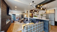 Located at 8255 West Limelight Street in Boise, Idaho, this single-floor amenity space offers a thoughtfully designed environment that blends contemporary style with practical functionality. The centerpiece of the space is an expansive clubroom and lounge area, anchored by a striking full kitchen featuring stainless steel appliances, light wood cabinetry, open shelving, and a bold patterned tile backsplash. A long, bookmatched green marble bar counter with bar-height seating extends along one side, providing ample space for social gatherings. Exposed dark ceiling beams, pendant lighting, and warm hardwood flooring throughout lend the space a modern yet inviting ambiance. The lounge area is furnished with plaid and textured upholstered sofas and chairs arranged around low wooden tables, creating comfortable conversation zones. Two dedicated conference rooms serve professional needs — one features bold damask-patterned wallpaper and leather executive chairs around a central table, while a smaller room offers a clean, minimal design with large windows and a wall-mounted display. The fitness center is generously proportioned, housing a comprehensive range of cardio and strength-training equipment, with large industrial-style windows allowing natural light to fill the space. Together, these areas create a versatile and well-appointed community facility.