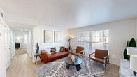 Located at 8101 Cantrell Rd in Little Rock, Arkansas, this 2-bedroom, 1-bathroom residence offers a clean, modern aesthetic throughout its thoughtfully arranged single floor. The living room serves as the heart of the home, featuring light wood-style flooring, crisp white walls, and large windows that invite abundant natural light. The open layout accommodates a comfortable seating arrangement and connects seamlessly to the rest of the space via a well-lit hallway. The galley-style kitchen is efficiently designed with white shaker cabinetry, granite-look countertops, black hardware accents, a stainless steel sink, and black appliances, making excellent use of the available space. The spacious primary bedroom is generously sized, offering plush carpet flooring, dual windows, a ceiling fan, and a textured ceiling, providing a comfortable and private retreat. The second bedroom mirrors the same cozy carpeted finish and includes crown molding and natural light. The shared bathroom features a clean, minimalist design with white cabinetry and a well-lit vanity. With four closets distributed throughout, storage is ample. The consistent use of light tones, modern fixtures, and wood-look flooring in common areas gives this residence a cohesive, contemporary feel.