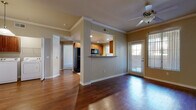This single-floor residence offers a thoughtfully designed layout that balances open communal spaces with comfortable private areas. The living room serves as the heart of the home, showcasing rich, dark hardwood flooring, crown molding, and a ceiling fan, while large windows and a glass-paneled door bathe the space in natural light. A half-wall pass-through connects the living area to the kitchen, maintaining an open, airy feel throughout.

The galley-style kitchen is well-equipped with warm-toned wood cabinetry, granite countertops, stainless steel appliances including a refrigerator, range, and built-in microwave, and a stainless steel sink. Light tile flooring and a window above the counter further brighten the space.

The bedrooms are finished with plush carpeting and feature ceiling fans and vertical blinds that filter natural light. Each room offers a generous sense of space with clean, neutral wall tones that complement the overall aesthetic.

The bathroom is finished with tile flooring and includes a tub-shower combination enclosed by sliding glass doors, providing a clean and functional design. Throughout the residence, consistent warm neutral tones, white trim, and crown molding create a cohesive and welcoming ambiance.