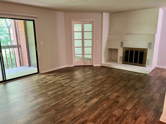 Living room with fireplace, private deck and home office behind French doors - 117 Turtle Creek Rd