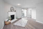 This single-floor residence offers a thoughtfully designed layout that balances comfort and modern style throughout. The living room serves as the heart of the home, anchored by a white brick wood-burning fireplace and complemented by warm wood-look flooring. A sliding glass door fills the space with natural light and provides access to an outdoor area, creating a bright and welcoming atmosphere.

The kitchen is outfitted with sleek dark cabinetry, striking quartz countertops with marble-like veining, a stainless steel double-basin sink with a modern gooseneck faucet, and a classic white subway tile backsplash — combining functionality with contemporary design.

Two bedrooms offer a comfortable retreat, each featuring plush carpeting, neutral wall tones, and windows with blinds that allow for natural light and privacy. The rooms provide a calm, versatile space suitable for a variety of uses.

Two bathrooms serve the home, each finished with wood-look flooring, dark vanity cabinetry, and white countertops. One bathroom includes a tub-shower combination, while the other features a walk-in shower, both finished with clean, modern fixtures.

Overall, the space presents a cohesive, updated aesthetic with neutral tones, quality finishes, and a practical floor plan.