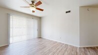 This single-floor unit offers a bright and functional layout finished with light wood-style luxury vinyl flooring that runs consistently throughout the space, lending a cohesive and modern feel to every room. The open living area is a comfortable size, equipped with a ceiling fan and a sliding glass door fitted with vertical blinds that provides direct access to an outdoor area and allows natural light to fill the room.

The bedrooms are well-proportioned and versatile. One bedroom features a ceiling fan, a window with horizontal blinds offering exterior views, and a mirrored sliding closet, while additional bedrooms maintain the same neutral palette and wood-style flooring for a clean, move-in-ready appearance.

The full bathroom is outfitted with a tiled shower-tub combo, a white vanity with ample counter space, a framed mirror with brushed silver accents, and wood-style flooring. A separate water closet provides added privacy and convenience. The space also includes a dedicated laundry area with a side-by-side washer and dryer, adding practical in-unit functionality.

Throughout the unit, neutral walls, white trim, and HVAC vents contribute to a clean, well-maintained atmosphere designed for comfortable everyday living.