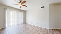 This single-floor unit offers a bright and functional layout finished with light wood-style luxury vinyl flooring that runs consistently throughout the space, lending a cohesive and modern feel to every room. The open living area is a comfortable size, equipped with a ceiling fan and a sliding glass door fitted with vertical blinds that provides direct access to an outdoor area and allows natural light to fill the room.

The bedrooms are well-proportioned and versatile. One bedroom features a ceiling fan, a window with horizontal blinds offering exterior views, and a mirrored sliding closet, while additional bedrooms maintain the same neutral palette and wood-style flooring for a clean, move-in-ready appearance.

The full bathroom is outfitted with a tiled shower-tub combo, a white vanity with ample counter space, a framed mirror with brushed silver accents, and wood-style flooring. A separate water closet provides added privacy and convenience. The space also includes a dedicated laundry area with a side-by-side washer and dryer, adding practical in-unit functionality.

Throughout the unit, neutral walls, white trim, and HVAC vents contribute to a clean, well-maintained atmosphere designed for comfortable everyday living.