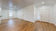 Located at 300 SW 2nd Pl in Newcastle, Oklahoma, this single-story home offers a comfortable and cohesive layout across two bedrooms, two bathrooms, and a dedicated laundry room. Rich wood-look tile flooring flows throughout the main living areas, kitchen, and bathrooms, lending a warm, consistent aesthetic to the home. The open kitchen is well-equipped with warm oak cabinetry, granite countertops, and a full suite of stainless steel appliances, including a range, over-the-range microwave, and dishwasher. The living room features recessed lighting and a bright, open feel with vaulted ceilings and access to the exterior. Both bedrooms are carpeted and include ceiling fans; the primary bedroom benefits from a vaulted ceiling, while the secondary bedroom features natural light from a window with views to the outdoors. The two bathrooms mirror the home's design language with granite vanity tops, oak cabinetry, and wood-look tile floors. One bathroom includes a tiled tub/shower combination, while the other features a tiled walk-in shower. The laundry room includes overhead oak cabinetry for added storage. The attached two-car garage completes this functional and inviting home.