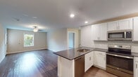 Located at 29568 Brant Ct in Easton, Maryland, this single-floor home offers a clean, modern design throughout. The open-concept layout connects the kitchen and living area seamlessly, creating a bright and functional space ideal for everyday living and entertaining. The kitchen is well-appointed with white shaker-style cabinetry, dark granite-look countertops, a central island with a built-in sink, and a full suite of stainless steel appliances including a refrigerator, range, microwave, and dishwasher. Recessed lighting illuminates the kitchen, while the adjacent living area features wood-look flooring and a ceiling fan. The bedrooms are generously sized, each featuring ceiling fans with light fixtures and windows overlooking lush greenery, providing an abundance of natural light. The bedrooms include a mix of hardwood-style and carpeted flooring. Two full bathrooms serve the home, each finished with white vanity cabinetry, large mirrors, and wood-look tile flooring. One bathroom features a tub-shower combination, while the other is similarly appointed. Throughout the home, neutral tones and clean lines create a cohesive, move-in-ready atmosphere.