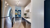 Located at 685 S Reed Ct in Lakewood, Colorado, this well-designed two-bedroom, two-bathroom residence offers a thoughtful single-floor layout with a cohesive modern aesthetic. The living room immediately impresses with dramatically soaring ceilings and a striking bold blue accent wall adorned with a gallery of framed artwork, creating an airy, artistic atmosphere. Light wood-style flooring flows seamlessly throughout the space, tying each room together.

The adjacent dining area continues the bold blue palette and features angled ceilings, adding architectural character to the intimate setting. The galley-style kitchen is efficiently designed with crisp white upper cabinetry, dark espresso lower cabinets, white quartz countertops, a stainless steel sink, and a classic subway tile backsplash — balancing style and function.

The primary bedroom offers a comfortable retreat, highlighted by a bold blue accent wall, a closet with sliding doors, and a window that invites natural light. The second bedroom maintains the same bright, clean aesthetic. Both bathrooms are finished with wood-style flooring, clean white surrounds, and dark vanity cabinetry. A dedicated closet and hallways provide practical storage throughout. This residence delivers a stylish, modern living experience in a compact and well-utilized footprint.