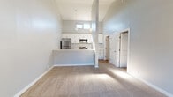 Located at 640 W Lincoln Ave in Escondido, California, this single-floor residence offers a thoughtfully designed layout with a bright, open feel throughout. The living area immediately impresses with dramatic vaulted ceilings that create a generous sense of volume, complemented by soft carpeting and cool-toned gray walls that lend a clean, modern aesthetic. Natural light filters in through elevated windows, enhancing the airy atmosphere.

The kitchen is seamlessly integrated into the living space via a peninsula-style breakfast bar, making it ideal for both cooking and entertaining. White shaker-style cabinetry pairs with stone-look countertops, while stainless steel appliances — including a refrigerator, over-the-range microwave, and electric range — provide a polished, functional finish. Light wood-look flooring runs throughout the kitchen, adding warmth and contrast.

The bedrooms are generously proportioned, each featuring plush carpeting, soft gray walls, and windows that bring in natural light and views of the surrounding greenery. The bathroom is well-appointed with a marble-look vanity countertop, white shaker cabinetry, a framed mirror, and a full shower-tub combination, all finished with light wood-look flooring for a cohesive, contemporary look. The unit also features a private entry door with exterior access.