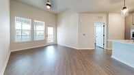 Located at 4555 Grove Springs Cir in Apopka, FL, this single-story, 2-bedroom, 2-bathroom home offers 1,020 square feet of well-designed living space. The open-concept kitchen and living area serves as the heart of the home, featuring white cabinetry, a central island with a black matte faucet and sink, white quartz countertops, stainless steel appliances, subway tile backsplash, and stylish pendant lighting. Wood-look luxury vinyl flooring flows throughout the entire unit, creating a warm and cohesive aesthetic. The primary bedroom spans 180 square feet and includes a ceiling fan and a spacious walk-in closet with wire shelving. The second bedroom offers natural light through multiple windows with exterior views. Both closets feature wire shelving systems for organized storage. The primary bathroom includes a glass-enclosed walk-in shower with tile surround and a modern floating vanity with matte black hardware, while the second bathroom features a tub-shower combo with large-format tile. A dedicated laundry room with a full-size washer and dryer completes this functional and contemporary home.