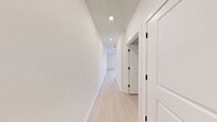 Located at 900 E Sligh Ave in Tampa, Florida, this single-floor unit offers a thoughtfully designed layout that maximizes its compact footprint. The interior features a clean, modern aesthetic throughout, with light wood-look flooring and bright white walls that contribute to an open, airy atmosphere.

The kitchen is a standout feature, outfitted with full stainless steel appliances including a French door refrigerator with ice maker, a gas range, over-the-range microwave, and dishwasher. Crisp white shaker-style cabinetry extends to the ceiling, providing ample storage, while a subway tile backsplash and light-toned countertops complete the contemporary look. Recessed lighting illuminates the space efficiently, and an island provides additional workspace and storage.

The bathroom is finished in a clean, neutral palette, featuring a tub-shower combination with floor-to-ceiling marble-look tile surround and matte black hardware and fixtures, adding a refined contrast to the bright white walls and light flooring.

A dedicated walk-in closet offers wire shelving and hanging space, providing practical, organized storage. The overall design of the unit emphasizes functionality and modern styling throughout.