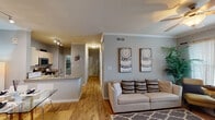 This thoughtfully laid-out 2-bedroom, 2-bathroom residence in Houston, TX presents a comfortable and functional single-floor design. The open-concept living and dining area features wood-look flooring, crown molding, and a ceiling fan, creating a warm and inviting atmosphere. Large windows allow natural light to fill the space, with a patio door providing additional brightness and outdoor access.

The kitchen is equipped with granite countertops, cream cabinetry, stainless steel appliances including a range and over-the-range microwave, and a breakfast bar peninsula that connects seamlessly to the dining and living areas. Track lighting overhead adds a polished touch.

A well-lit hallway adorned with decorative mirrors leads to both bedrooms. Each bedroom features plush carpeting, ceiling fans, and windows with blinds and curtain rods. The primary bedroom includes an en-suite bathroom and access to a closet. Both bathrooms offer wood-look flooring, vanities with storage cabinetry, and tub-shower combinations.

Additional highlights include a dedicated laundry area with utility access and ample closet storage throughout. The neutral gray tones and crown molding details throughout the home create a cohesive, modern aesthetic.