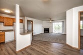 Located in West Des Moines, Iowa, this well-appointed 2-bedroom, 2-bathroom residence offers a comfortable and functional single-floor layout. The open-concept living and dining area is anchored by a tile-surround fireplace with a classic white mantel, while a ceiling fan and sliding glass door lead to a private balcony, filling the carpeted space with natural light and outdoor views. The kitchen features warm oak cabinetry, dark countertops, a peninsula breakfast bar with additional counter seating, and white appliances including a refrigerator, range, and dishwasher — all flowing seamlessly into the living area over durable hardwood-style flooring. The generously sized primary bedroom includes a ceiling fan, natural light from a large window, a mirrored sliding-door closet, and direct access to an en-suite bath. The second bedroom also features a ceiling fan and plush carpet. Both bathrooms are clean and functional, with one offering a full soaking tub and shower combo. A dedicated in-unit laundry area accommodates a full-size washer and dryer. Three closets throughout provide ample storage, and a utility room adds practical convenience. The overall aesthetic is bright, neutral, and move-in ready.