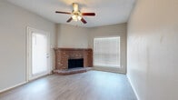 This well-appointed 1-bedroom, 1-bathroom single-floor unit offers a thoughtfully designed layout across a comfortable footprint. The combined kitchen and living area serves as the heart of the space, highlighted by a standout corner brick fireplace that adds warmth and character. A ceiling fan with a light fixture keeps the space comfortable, while large windows with blinds invite ample natural light throughout. Light wood-look flooring runs consistently through the living areas, creating a clean and cohesive aesthetic.

The kitchen is efficiently designed with dark espresso cabinetry, light countertops, a tiled backsplash, and a full suite of black appliances including a range, microwave, and dishwasher. A pass-through counter connects the kitchen to the living area, enhancing the open feel of the space.

The bedroom is a comfortable retreat with its own ceiling fan, a window for natural light, and direct access to a walk-in closet with built-in shelving. The bathroom features dark cabinetry with a light countertop, a large mirror with vanity lighting, and additional storage. A hallway connects the private areas of the unit. Throughout, neutral wall tones and consistent flooring tie the space together into a cohesive, functional home.